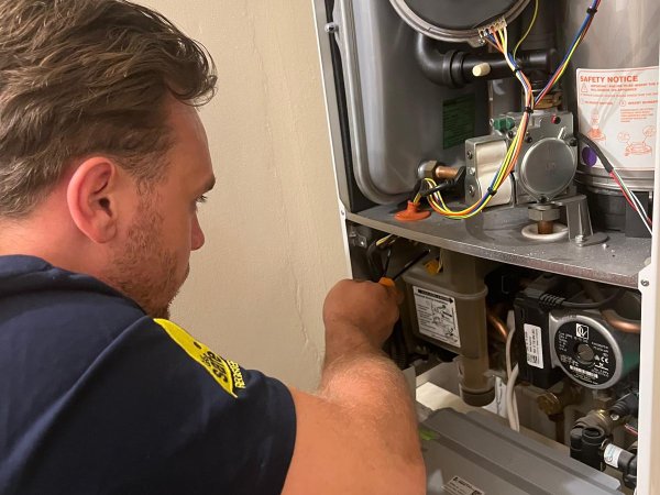 Engineer diagnosing a boiler fault with the front panel removed
