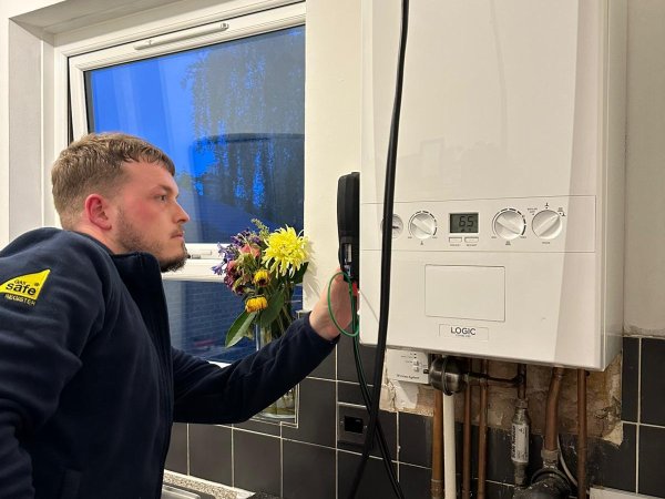Gas engineer completing a landlord gas safety inspection on a wall-mounted boiler